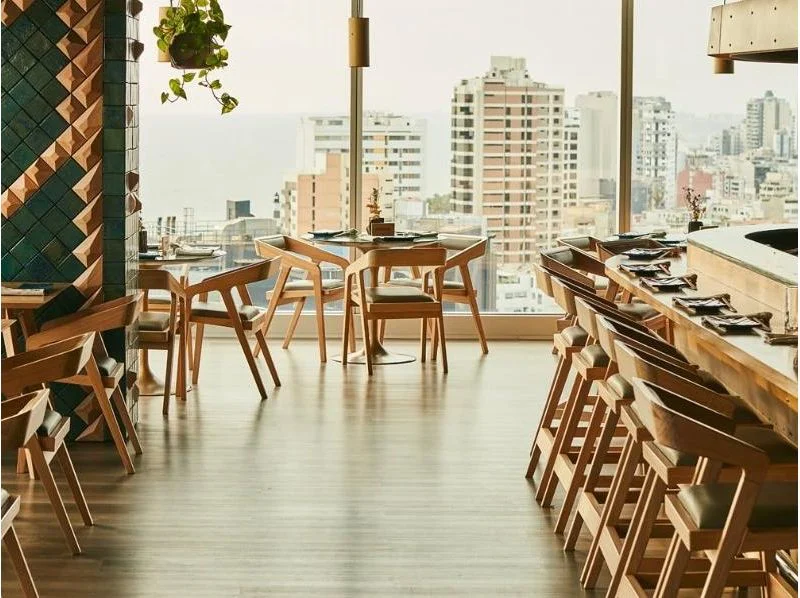 La barra y las mesas de Kimo junto a los ventanales de Miraflores