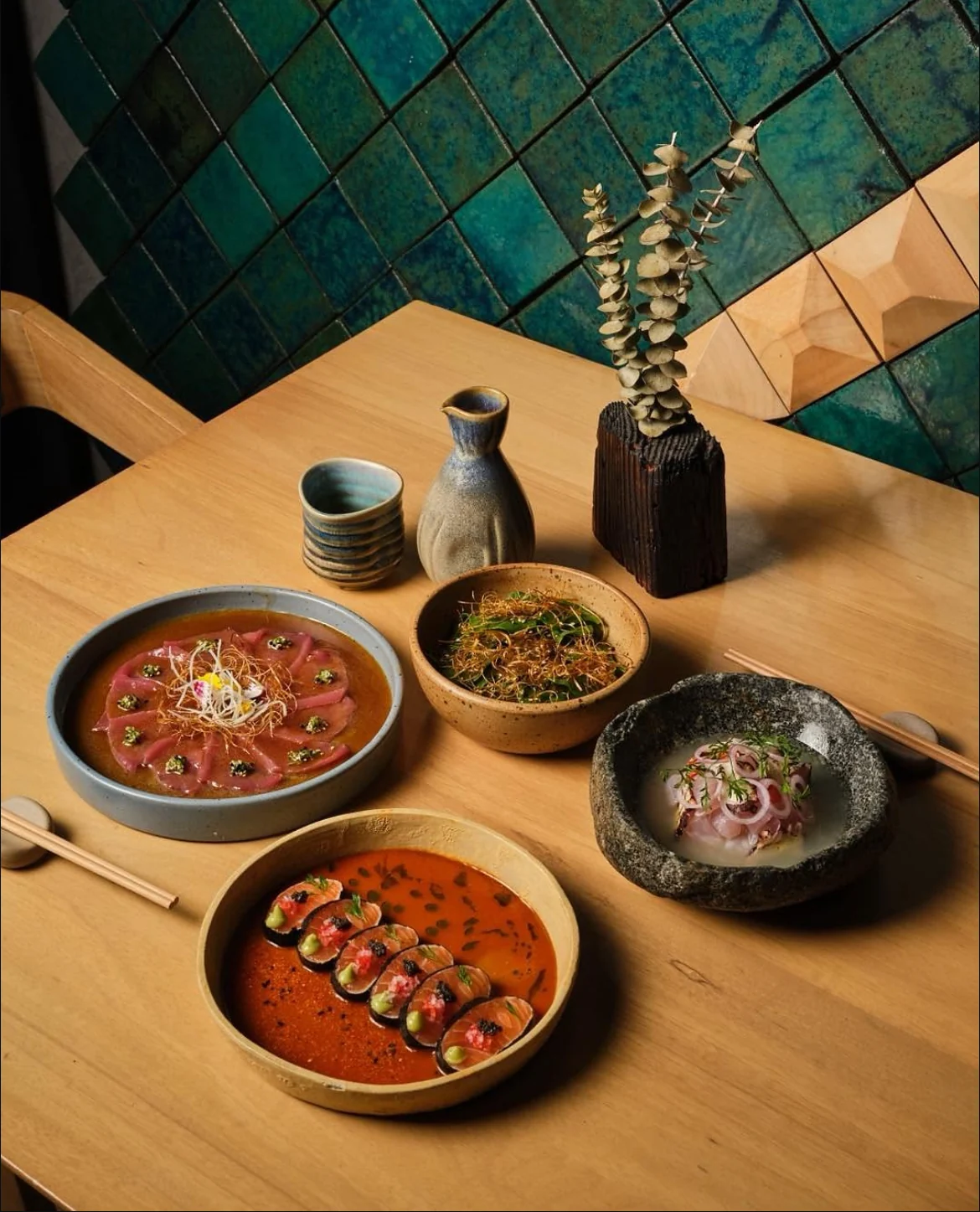 Platos de Kimo sobre la mesa, junto a la pared de azulejos verdes